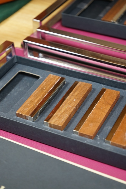 David Linley, two chrome and leather square trays together with two incomplete sets of menu holders. Condition - trays good, rests tarnished in places & would benefit from a clean